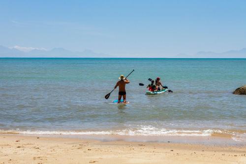 a group of people standing in the water on the beach at Casa Luz Paraty in Paraty