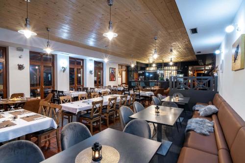 un restaurante con mesas y sillas en una habitación en RED DEER Hotel, en Brezno