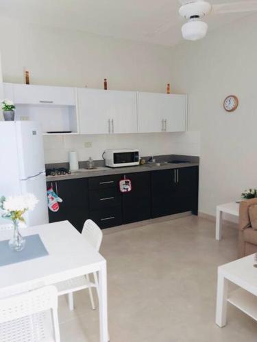 a kitchen with white cabinets and a white table at Apartahotel MACADANA in Nagua