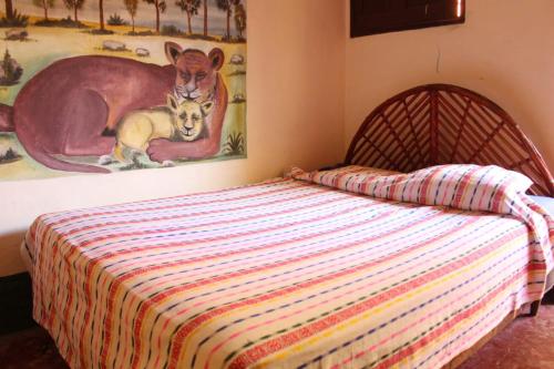 ein Schlafzimmer mit einem Bett und einem Känguru-Gemälde in der Unterkunft Hotel Bruno's Place in El Remate