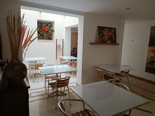 a dining room with tables and chairs and a window at Hotel Boutique Confort Suites in Popayan