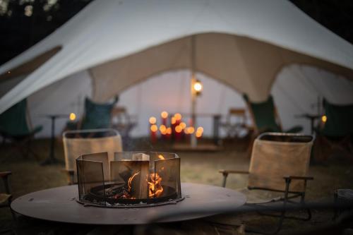 a tent with a table with a fire in it at THE HIRAMATSU KARUIZAWA MIYOTA in Miyota