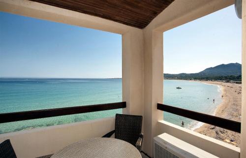 a balcony with a view of the beach at Hotel Beau Rivage in Algajola
