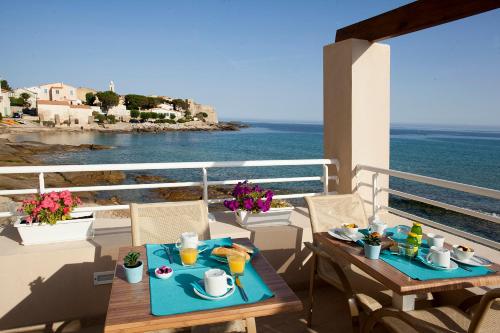 a dining room table with a balcony overlooking the ocean at Hotel Beau Rivage in Algajola