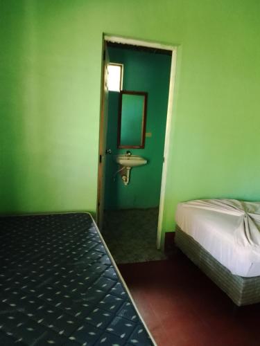 a bedroom with a bed and a sink and a mirror at Hospedaje la paloma in Moyogalpa