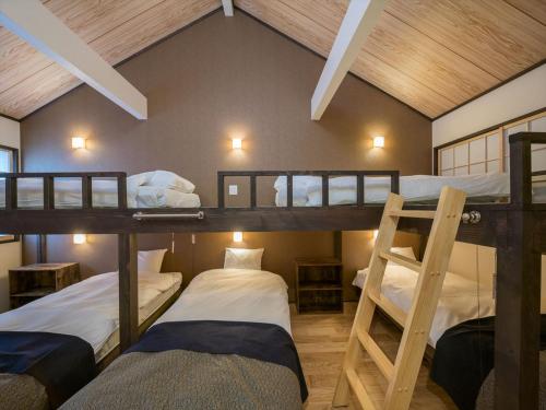 a room with three bunk beds in a house at YADOYA Matsugaya in Tokyo