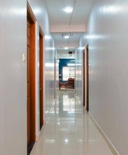 a hallway with two doors and a hallway with a couch at Reach Residency in Cochin