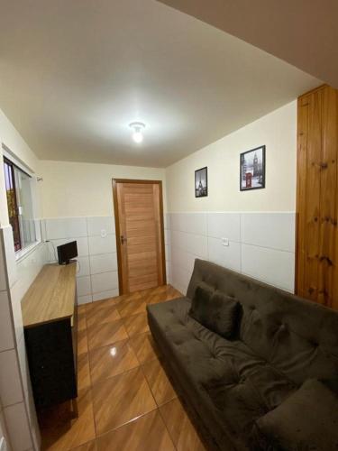 uma sala de estar com um sofá e uma mesa de madeira em Hospedaria São José em Treze Tílias