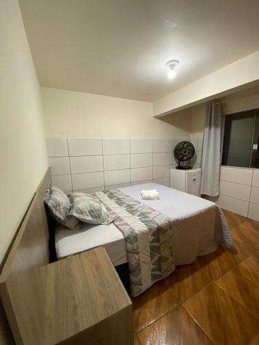 um pequeno quarto com uma cama e uma mesa em Hospedaria São José em Treze Tílias