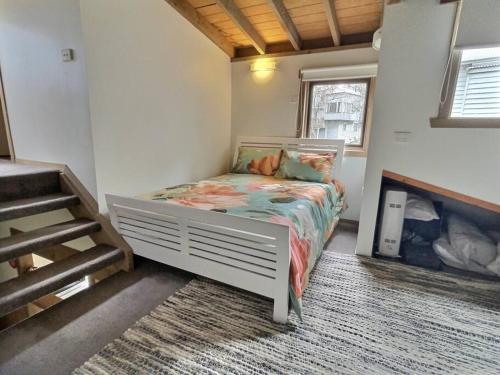 1 dormitorio pequeño con 1 cama en una habitación en Faithfulls Chalet, alpine-getaways, en Dinner Plain
