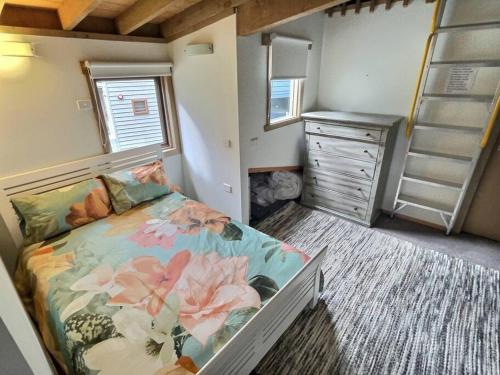 a bedroom with a bed and a dresser in a room at Faithfulls Chalet, alpine-getaways in Dinner Plain