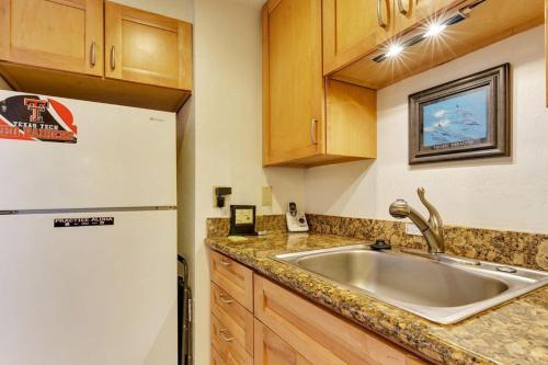 una cocina con fregadero y refrigerador en Nohonani 104, en Kahana