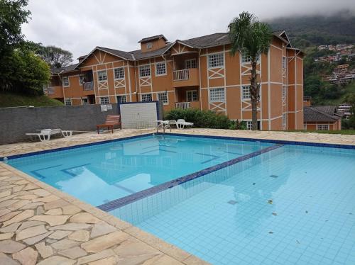 uma grande piscina em frente a um edifício em Apartamento Vivendas do Eucalipto em Petrópolis