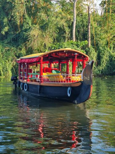a boat floating down a river in the water at Chilanka Lake View Resort in Alleppey