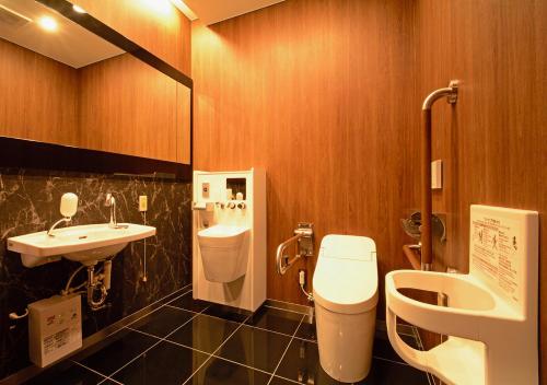 a bathroom with a toilet and a sink at APA Hotel Kagoshima Tenmonkan in Kagoshima