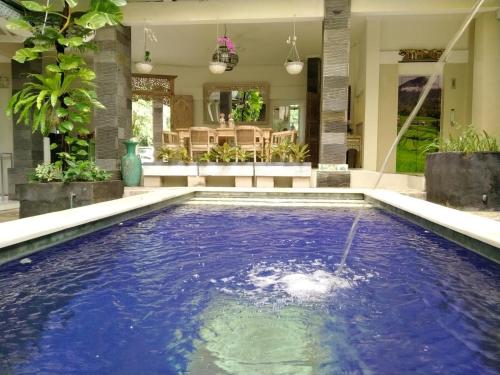 a swimming pool in the middle of a house at Su's Cottages Legian in Legian