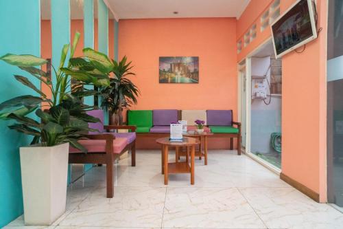 a waiting room with purple and green chairs at Sans Hotel FiFFa Pisang Kipas Malang in Malang
