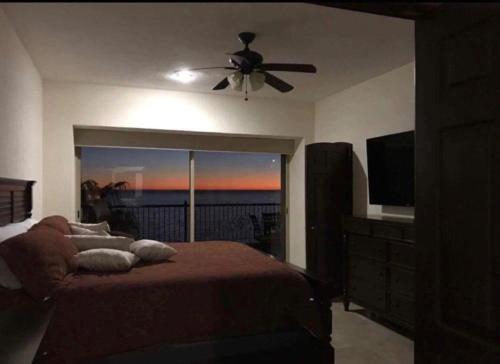 1 dormitorio con 1 cama y ventilador de techo en Sonoran Sky Resort Oceanview Condo, en Puerto Peñasco