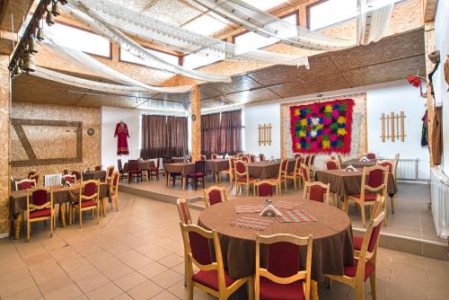 Un comedor con mesas y sillas y un cuadro. en Kamena Pamporovo, en Pamporovo