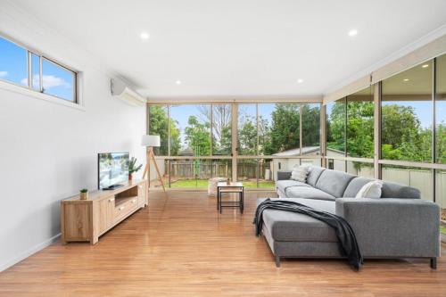 a living room with a couch and a tv at Big Stylish 3 bed house with Free Parking in Oatlands