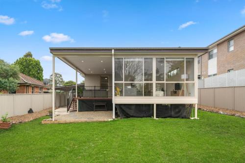a large glass extension of a house in a yard at Big Stylish 3 bed house with Free Parking in Oatlands