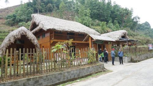 a group of people standing in front of a building at Homestay Khoáng nóng Thông Nguyên in Nam Giang