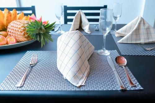 une table avec des fourchettes, des serviettes et une assiette de fruits dans l'établissement Chami Villa Bentota, à Bentota