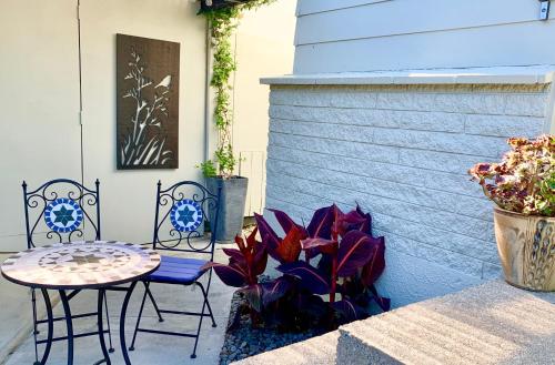 a patio with two chairs and a table and a plant at Koru Havenz in Picton