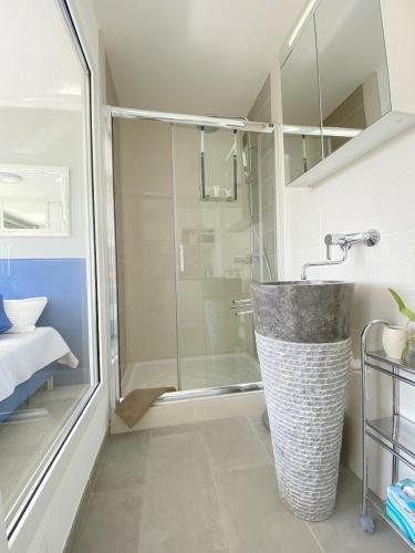 une salle de bain avec douche et lavabo dans l'établissement Cap d'agde Naturiste Heliopolis AB Vue Mer, au Cap d'Agde
