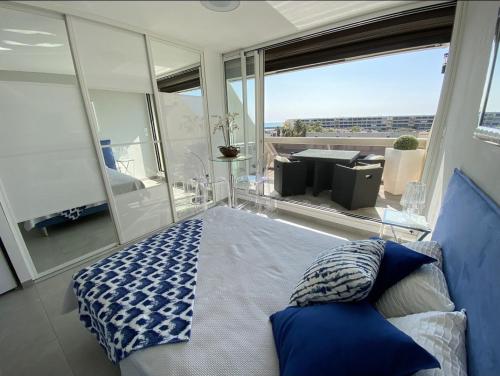 une chambre avec un lit et un balcon avec vue dans l'établissement Cap d'agde Naturiste Heliopolis AB Vue Mer, au Cap d'Agde