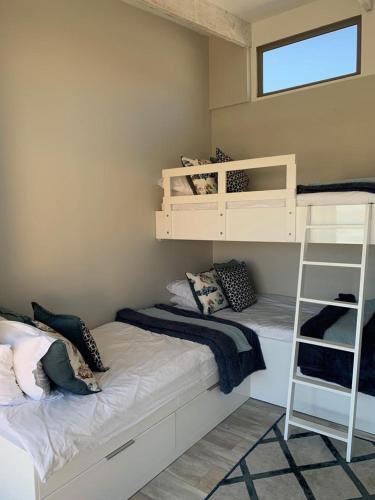 a bedroom with two bunk beds and a ladder at At Last Glentana Apartment in Groot Brak Rivier