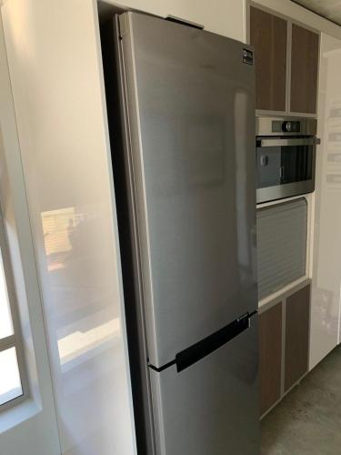 a stainless steel refrigerator in a kitchen at At Last Glentana Apartment in Groot Brak Rivier