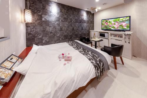 a hotel room with a bed and a television at Hotel ＧEM - Adult Only in Sendai