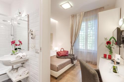La salle de bains est pourvue d'un lit, d'un lavabo et d'un miroir. dans l'établissement Rome River Inn, à Rome