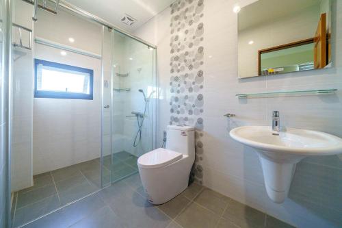 a bathroom with a toilet and a sink and a shower at Dreams Come True B&B in Xingjian