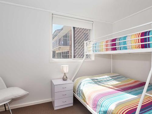 een slaapkamer met een stapelbed en een raam bij Shoreline, 4,7 Victoria Parade - Views over Fly Point and close to Nelson Bay Marina in Nelson Bay