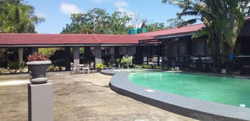 a resort with a swimming pool in front of a building at Mbazwana Inn in Mbazwana