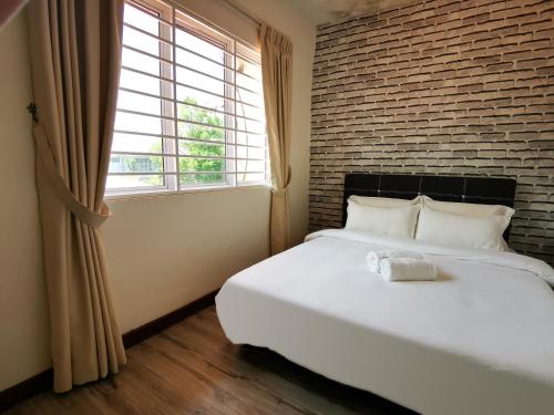 um quarto com uma cama branca e uma parede de tijolos em Double Storey Linked To KPJ Medical Specialist Centre Bdc 10BR By Natol Homestay-Paris em Kuching