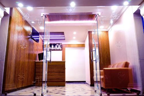 hol z krzesłem i szklanymi drzwiami w obiekcie Vismaya Comforts w mieście Mysuru