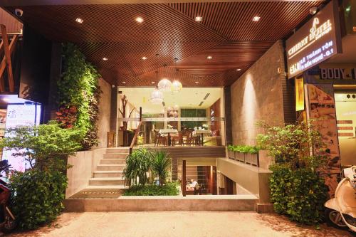 un vestíbulo de un edificio con escaleras y plantas en CHERRY BOUTIQUE HOTEL, en Ho Chi Minh