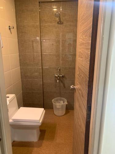 a bathroom with a toilet and a glass shower at Vismaya Comforts in Mysore