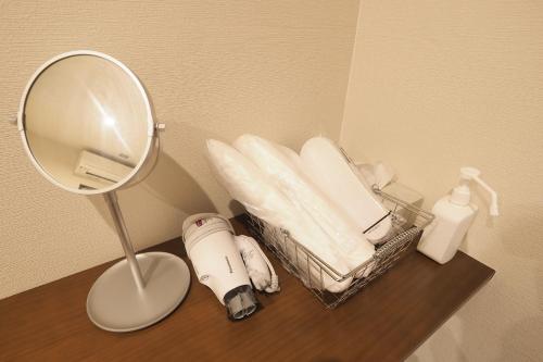 a table with a mirror and a pile of towels at Nekokura Hostel in Fukuoka