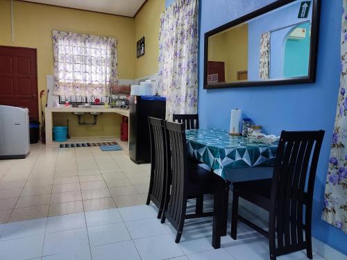uma sala de jantar com uma mesa azul e cadeiras em Riverview Homestay - Homestay Tepi Sungai Golok em Rantau Panjang