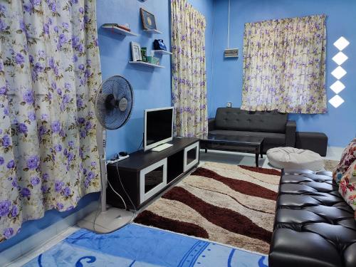 uma sala de estar com uma ventoinha e paredes azuis em Riverview Homestay - Homestay Tepi Sungai Golok em Rantau Panjang