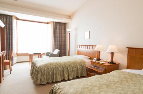 Llit o llits en una habitació de Chokai Sarukuraonsen Hotel Foresta Chokai