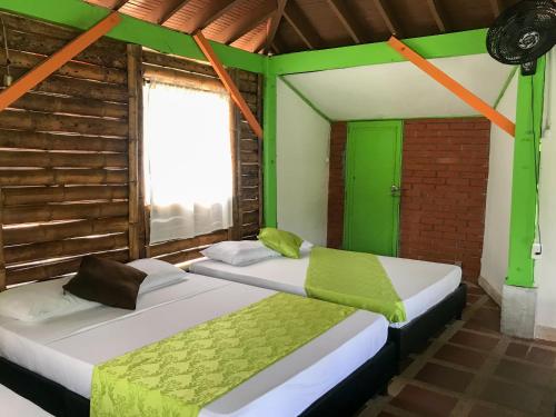 two beds in a room with a window at Room in Lodge - Family Cabin With Lake View in Rizaralda