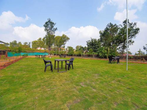 a group of tables and chairs in a park at Treebo The Appa'S Resort in Mahabaleshwar