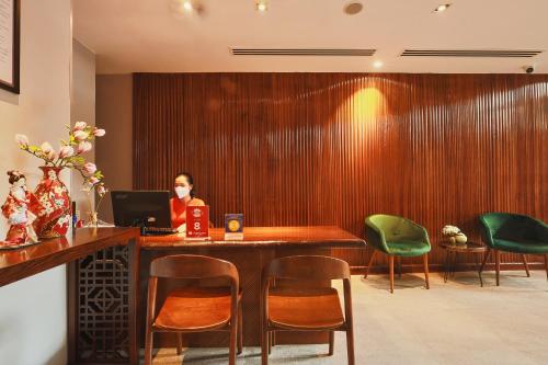 a woman sitting at a desk with a laptop at CHERRY BOUTIQUE HOTEL in Ho Chi Minh City