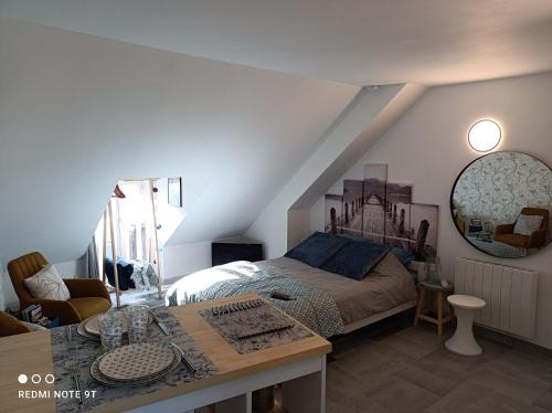 1 dormitorio con 1 cama y 1 mesa en Très beau studio Climatisation, Trois Etoiles, WiFi, Vélos en option, Parking Privé Jardin en Montargis