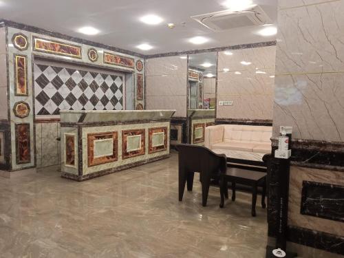 a living room with a couch and a table and a piano at Soukyam Hotel in Kolkata